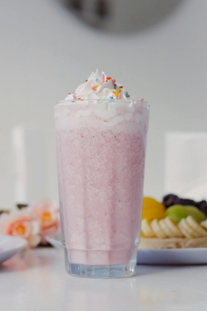 a pink drink sitting on top of a table
