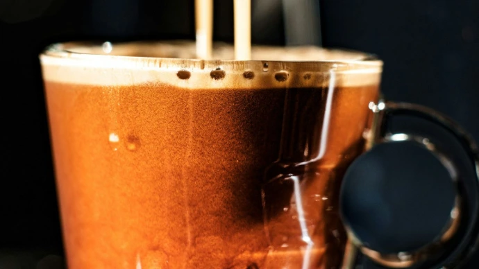 a cup of coffee being poured into it